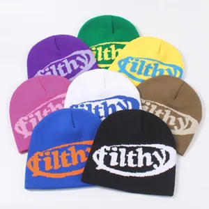 Detallada vista de múltiples gorros de punto coloridos con letras bordadas filthy.
