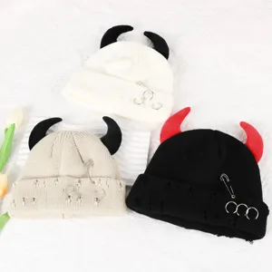 Detail view of the cute devil horn knitted beanie with metal ring and distressed details.