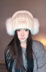 Gezellige gebreide muts met oorkleppen en schattig labeldetail voor warme winterdagen.