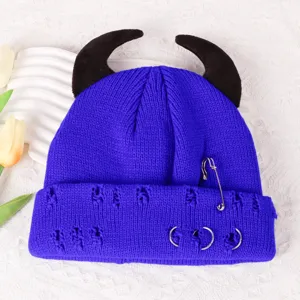 Close-up detail of knitted beanie featuring cute devil horns, metal rings, and punk safety pin.