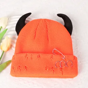 Orange knit beanie detail showcasing black devil horns, metal rings, and distressed ripped holes.