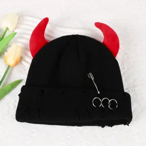 Black knitted beanie hat with red devil horns, metal rings and safety pin for autumn winter