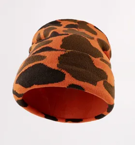 Gros plan de bonnet en tricot motif léopard orange marron hiver chaud chapeau détail.