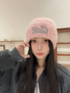 Cozy pink knitted beanie for women and men, featuring stylish front embroidery for autumn and winter.