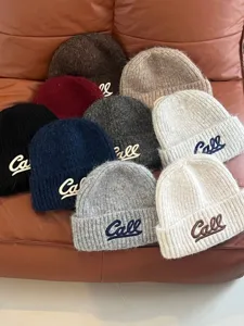 Detailed close-up view of winter warm knit beanie hats with stylish letter embroidery.