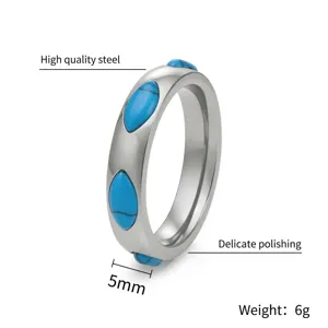 Dettaglio ravvicinato di un anello in acciaio al titanio con pietre turchesi marquise.