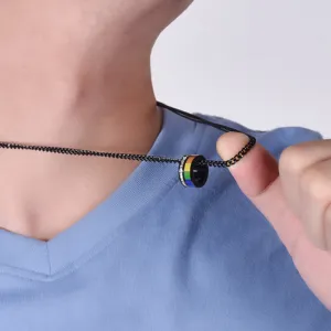 Close-up of a rainbow-striped stainless steel pendant on a black chain necklace