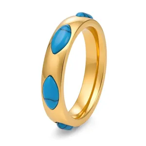 Dettaglio di un anello in acciaio al titanio dorato con pietre marquise turchesi.