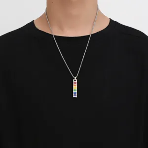 Close-up of men's titanium steel necklace with vertical rainbow enamel pendant on black tee.