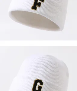 Weiß gestrickte Mütze mit besticktem Buchstaben, warmes und stylisches Winteraccessoire.