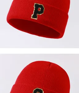 Red knitted beanie detail showcasing the classic alphabet patch and cozy winter wool texture.