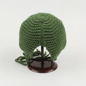 Detalle de gorro de punto verde con orejeras que muestra la textura y la forma de rana linda