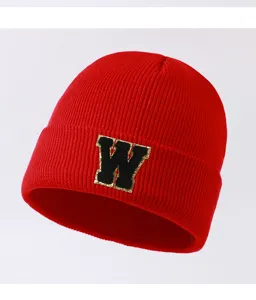 Detailed view of the red knitted beanie with black letter W patch, warm winter fashion hat.
