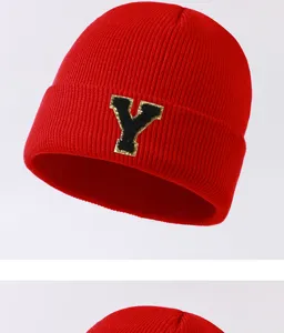Close-up detail of the red knitted winter beanie featuring a trendy letter Y patch decoration.