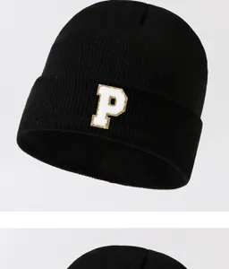 Close-up detail of black knitted beanie hat with white letter P patch for winter wear