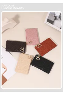 Detailed shot of stylish woven mini coin purses with keychains in various chic colors.