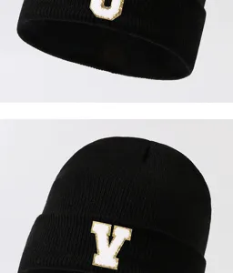 Detailed view of the black knit beanie with stylish letter patch, warm and cozy streetwear.