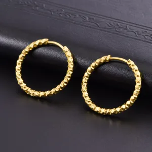 Primer plano detallado de pendientes de aro de acero inoxidable dorado con textura para mujer
