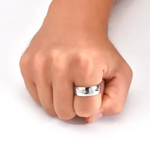 Gros plan d'une bague minimaliste pour homme en acier titane argenté avec pierre.