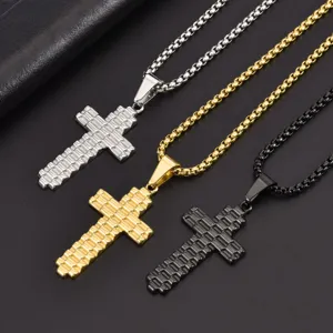 Close-up of textured cross necklaces in silver, gold, and black with box chains.