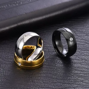 Gros plan de trois bagues minimalistes pour hommes en acier au titane en argent, or et noir.