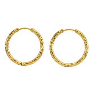 Detail of gold plated stainless steel hoop earrings with hammered texture.