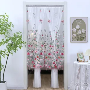 Cortina de puerta transparente bordada blanca con motivos florales y flecos de perlas.