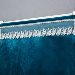 Detailed view of dark blue velvet door curtain featuring elegant white floral lace trim on top.
