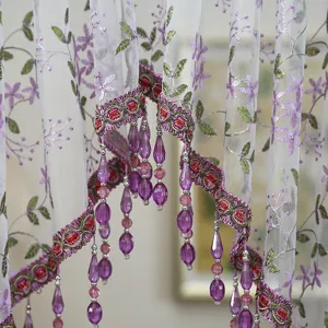Detailed view of decorative door curtain mesh lace with purple floral embroidery and beads.