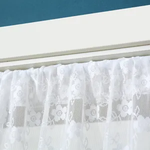 Λεπτομέρεια λευκής δαντελωτής κουρτίνας, διαφανές ύφασμα με λουλουδάτο μοτίβο για διακόσμηση.
