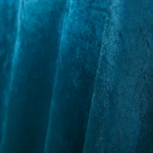 Close-up detail of luxurious teal velvet fabric with soft folds and elegant shimmer texture.