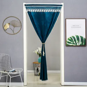 Detailed view of dark blue velvet door curtain with elegant white lace trim and hanging tie.