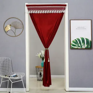Red velvet doorway curtain with white lace trim and gold tassel, elegant home decor scene.