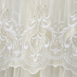 Exquisite white and gold embroidery lace sheer curtain fabric detail close up view.