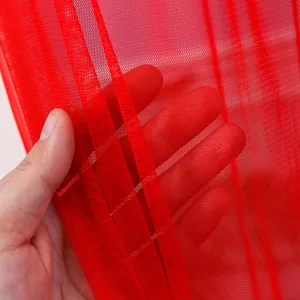 Red sheer mesh curtain fabric detail close up, breathable mosquito net material texture.