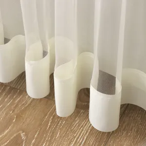 Detail shot of white sheer door curtain bottom hem, showing soft fabric waves and fine mesh texture.