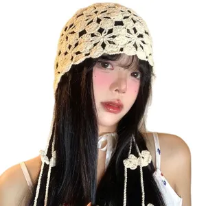 Cappellino da donna all'uncinetto con fiori e nappe, berretto in maglia elegante.