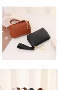 Detailed view of mini lychee pattern coin purse with wrist strap and secure keyring closure.