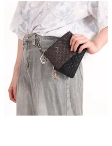 detail view of woven mini coin purse key chain storage bag in dark brown and black colors