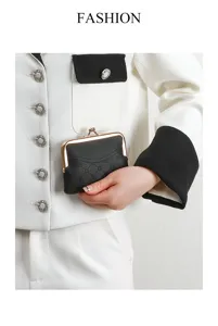 Detailed view of the black textured kiss-lock coin purse, highlighting hardware and design.