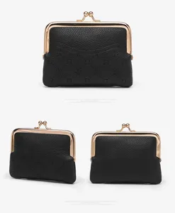 Classic black kiss-lock coin purse with gold metal frame, textured leather material, detail view.