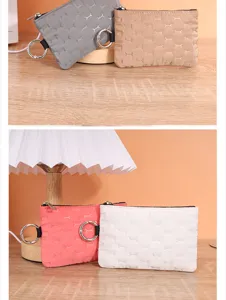 Detailed view of small quilted coin pouches featuring bone patterns and metal key rings.