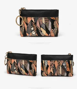Small coin purse with card slot and keyring, black and orange geometric pattern.