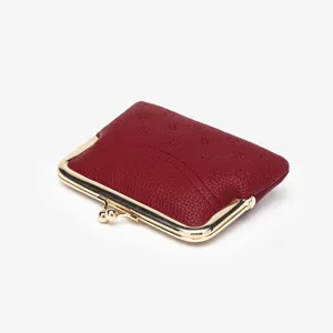 Red leather coin purse with vintage gold kiss-lock frame and chic debossed monogram pattern.