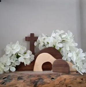 Escena detallada del sepulcro vacío de Pascua en madera con cruz y flores blancas decorativas