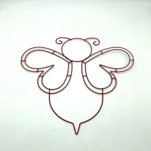 Detaillierte Makroansicht eines roten Metallrahmens in Bienenform für festliche Dekorationen.