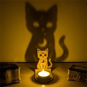 Detailansicht eines hölzernen Katzenkerzenhalters, der einen großen Katzenschatten wirft