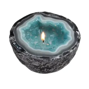 Detaillierte Nahaufnahme einer brennenden Duftkerze im blauen Geoden-Kristall-Resin-Design