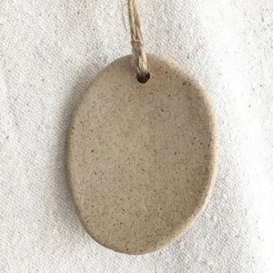 Detailed view of a rustic resin oval Christmas ornament with a natural hemp string