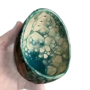 Handcrafted pottery herb stripper bowl featuring a unique blue bubble glaze pattern